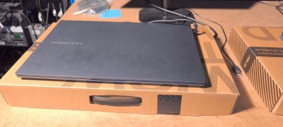 un ordinateur portable posé sur une boîte, sur une table