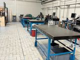 une grande salle équipée de tables et de bancs