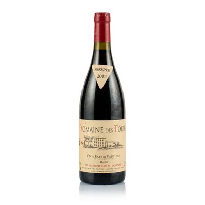 a bottle of red wine sitting on top of a white table