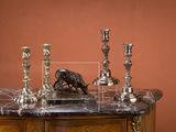 three candles on a table with a statue of a dog
