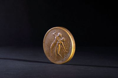 a close up of a gold coin on a black background