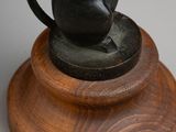 statue of a mouse on a wooden base with a white background