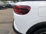 a white car parked in a parking lot with other cars in the background