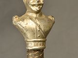 bronze statue of a man with a hat on top of a cane