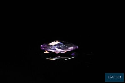 gros plan d'un diamant violet sur une surface noire