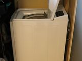 a washing machine in the corner of a small room