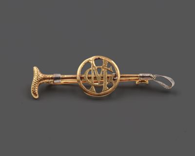 une image représentant une broche plaquée or ornée d'une corne
