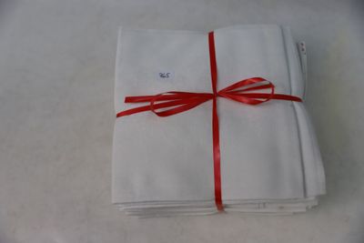 a stack of folded napkins tied with a red ribbon