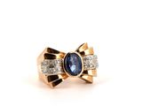 a close up of a ring with a blue stone and diamonds