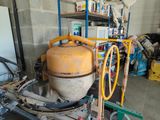 a machine that is sitting in a garage with a lot of stuff on the shelves