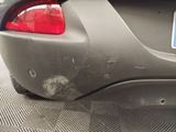 the rear end of a car with a dented bumper