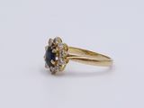 a close up of a gold ring with a sapphire and diamonds