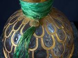 a glass jar with a green tassel on top of it