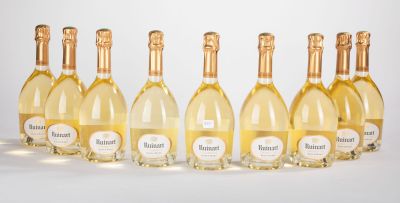 six bouteilles de vin blanc alignées sur une surface blanche