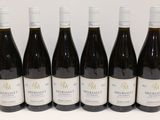 six bouteilles de vin sont alignées sur une table