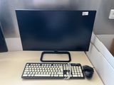 a keyboard and a mouse on a desk with a monitor