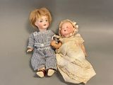 two dolls sitting next to each other on a table