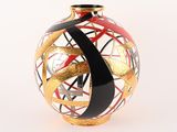 un vase noir et doré orné d'un motif rouge