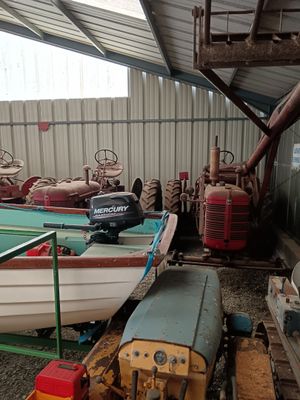 a small boat sitting in a shed next to a small boat