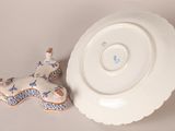 a white plate with a dog figurine next to it