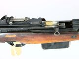 an old machine gun with a wooden barrel and a wooden handle