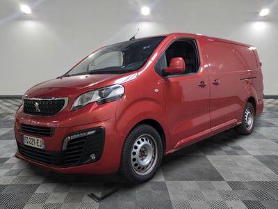 La camionnette rouge est garée sur un sol en dalles à damier.