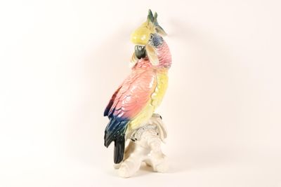 a figurine of a parrot sitting on top of a rock