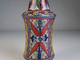 un vase coloré posé sur une table, sur fond blanc