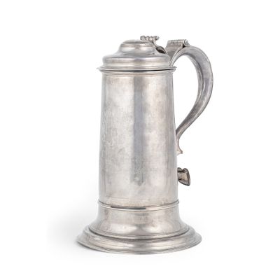 une chope ancienne en métal argenté avec une anse, sur fond blanc