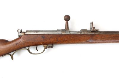 un gros plan d'un fusil sur une surface blanche avec un fond blanc