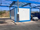 une photo d'un bâtiment bleu et blanc devant lequel est garée une voiture