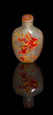 a glass bottle with a red and yellow design on it