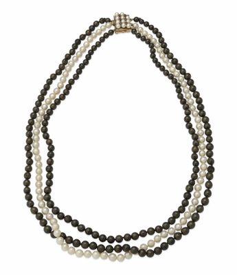 a three strand necklace with black and white pearls