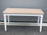 une table blanche avec un plateau en bois dans la rue