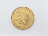 a close up of a gold coin on a white surface