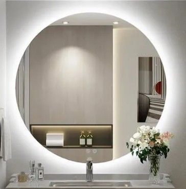 un grand miroir rond au-dessus d'un lavabo dans une salle de bains