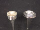 two metal objects that are sitting on a black surface