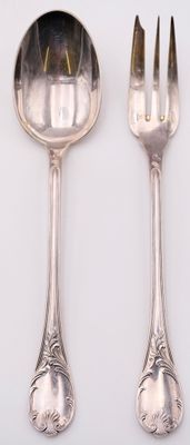 two spoons and a fork on a white table