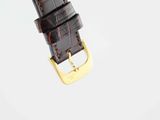 a close up of a watch strap with a gold buckle
