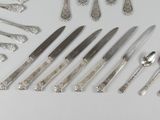 a lot of silver spoons and knives on the table
