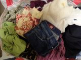 un panier rempli de vêtements posé sur un lit