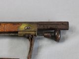 an old gun with a wooden handle on a white surface