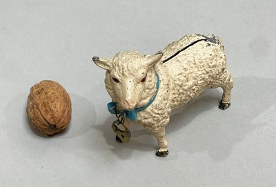 a figurine of a sheep and a walnut on a table