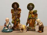 trois figurines représentant des personnes d'origine asiatique, posées sur une table