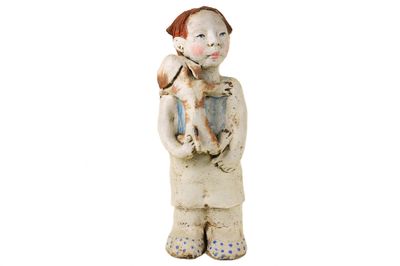 une figurine représentant un garçon tenant un chat dans ses bras