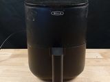 a black air fryer sitting on top of a wooden table