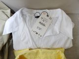 a white shirt and a yellow shirt sitting on a couch