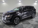 Un SUV noir est garé sur un sol à damier dans un garage.
