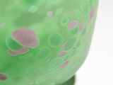 a green vase with pink and green dots on it