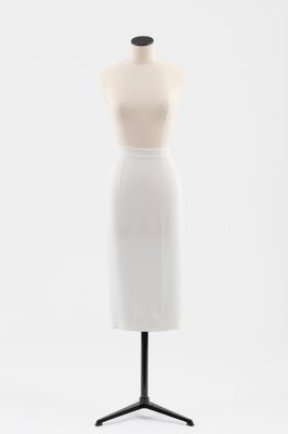 un gros plan d'un mannequin vêtu d'une jupe blanche, posé sur un socle